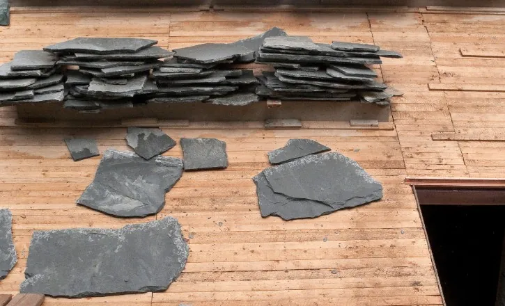 Montaje del rastrel de madera y acopio de pizarra sobre la cubierta